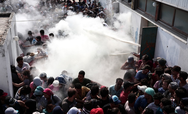 Cảnh sát xịt chất chữa cháy để giải tán những người di cư cô gắng đăng ký tị nạn trên đảo Kos, Hi Lạp.