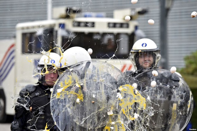 Nông dân biểu tình ném trứng vào cảnh sát chống bạo động trước trụ sở của Hội đồng châu Âu ở Brussels, Bỉ.