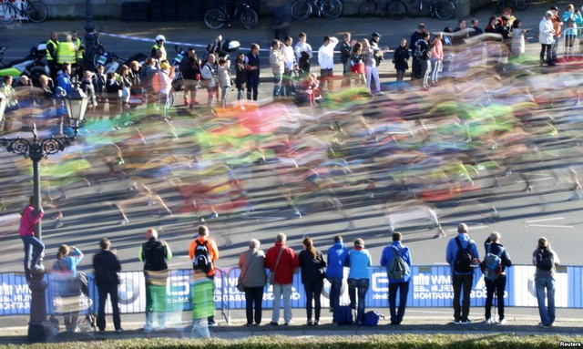 Mọi người đứng xem các vận động viên tham gia cuộc thi chạy marathon ở Berlin, Đức.