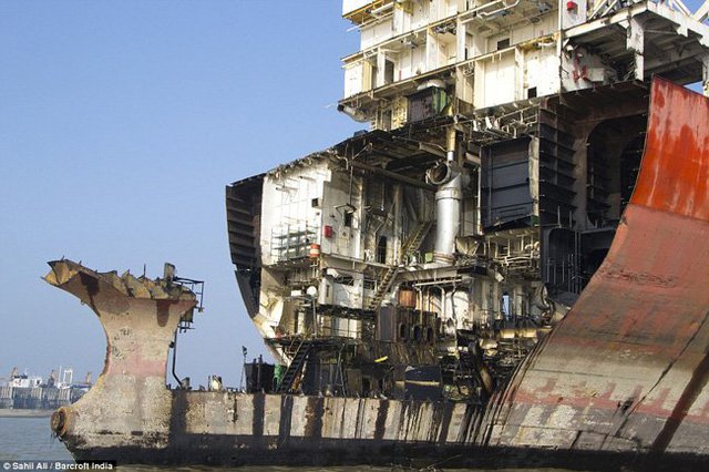 Một tàu vận tải lớn đã được phá dỡ một phần. Những mảnh kim loại phá dỡ sẽ được nấu lại để mang đi bán.