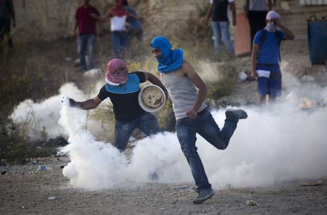 Người biểu tình Palestine ném lựu đạn hơi cay trở lại binh sĩ Israel trong cuộc đụng độ gần thành phố Ramallah, Bờ Tây.