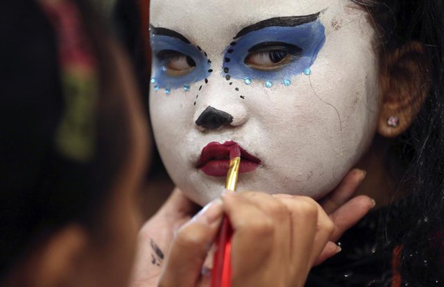 Bé gái được trang điểm trước khi tham dự một sự kiện Halloween ở Manila, Philippines.