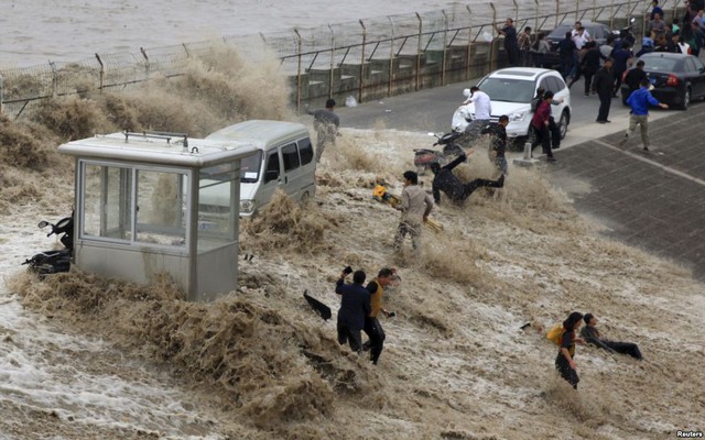 Du khách bị sóng thủy triều đánh ngã trên bờ sông Tiền Đường ở thành phố Hàng Châu, Trung Quốc.