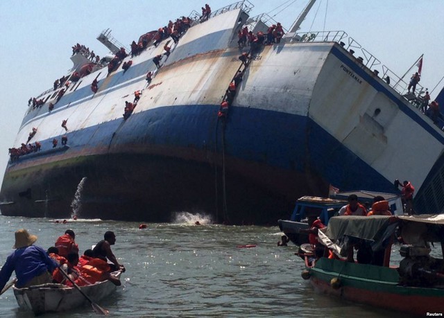 
Hành khách trèo khỏi chiếc tàu KM Wihan Sejahtera khi nó đang chìm dần ngoài khơi cảng Tanjung Perak ở Surabaya, Indonesia.
