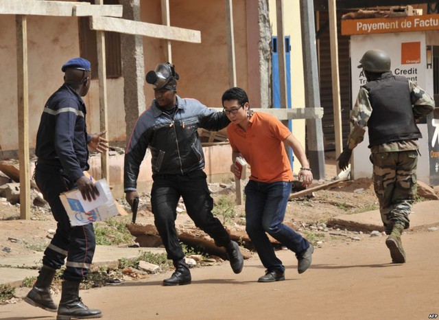 Lực lượng an ninh sơ tán một người đàn ông khỏi hiện trường vụ bắt cóc con tin tại khách sạn Radisson Blu ở Bamako, Mali.