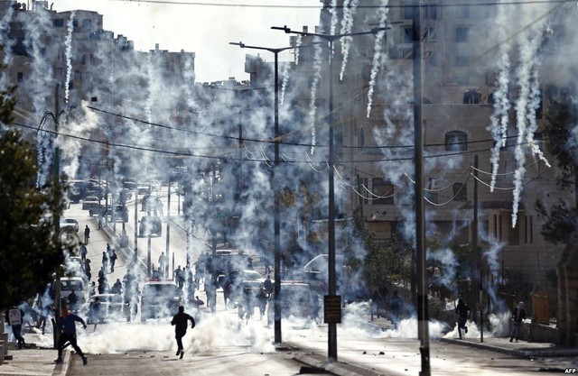 Người biểu tình Palestine ném đá trong khi cảnh sát Israel bắn đạn hơi cay trong cuộc đụng độ ở thành phố Bethlehem, Bờ Tây.