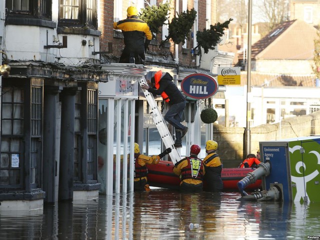 Các nhân viên cứu hộ giải cứu một nhóm người bị mắc kẹt trong ngôi nhà bị bao vây bởi nước lũ ở thành phố Tadcaster, Anh.