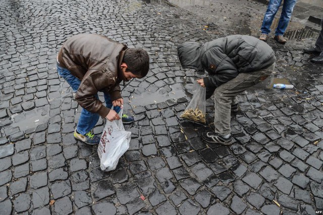 Trẻ em nhặt vỏ đạn rơi trên đường phố sau khi lệnh giới nghiêm được dỡ bỏ tại thành phố Diyarbakir, Thổ Nhĩ Kỳ.