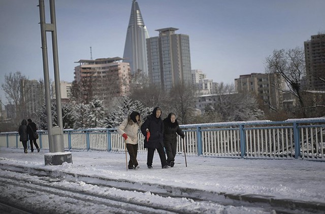 Ba cụ bà hỗ trợ nhau đi trên đường phủ đầy băng tuyết. (Nguồn: Sputniknews)