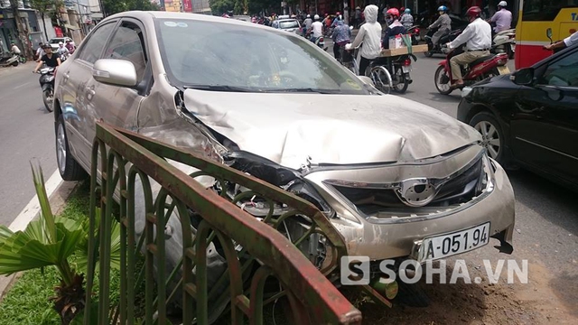 Tại hiện trường, chiếc xe bị hư hỏng nặng phần đầu, nhiều bộ phận rơi ra đường; khoảng 5 mét rào sắt bị xe húc đổ.