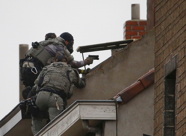 
Lực lượng cảnh sát đặc biệt của Bỉ trèo lên một căn nhà trong cuộc đột kích vừa diễn ra ở Molenbeek. Ảnh: Yves Herman/Reuters
