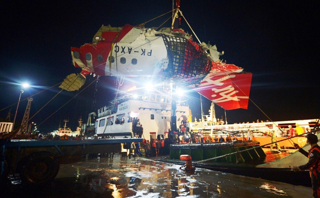 Một phần xác của máy bay QZ8501 được chuyển từ tàu cứu hộ sang xe tải tại cảng ở Kumai, Indonesia.