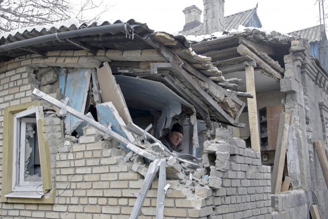 Người đàn ông dọn dẹp ngôi nhà của mình, sau khi bị tàn phá trong cuộc pháo kích gần đây tại thành phố Donetsk, Ukraine.