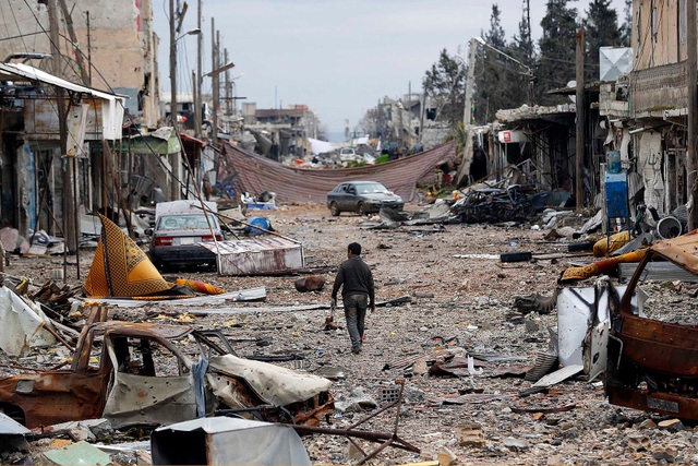 Người đàn ông đi giữa đường phố đổ nát tại thị trấn Kobani, Syria.