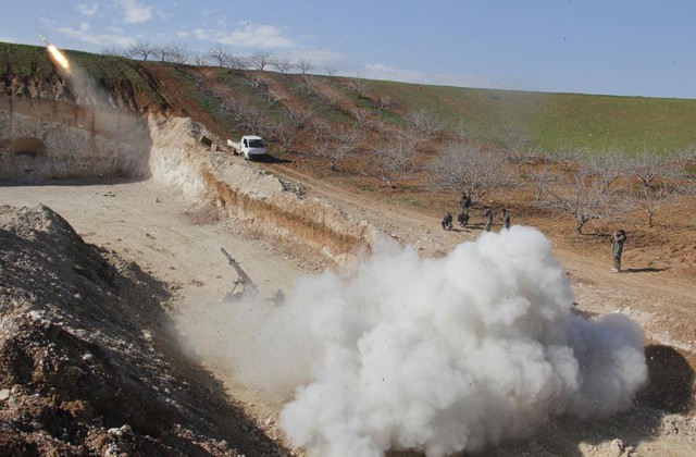 Chiến binh phiến quân Syria phóng rocket về phía quân đội chính phủ tại thành phố Hama.