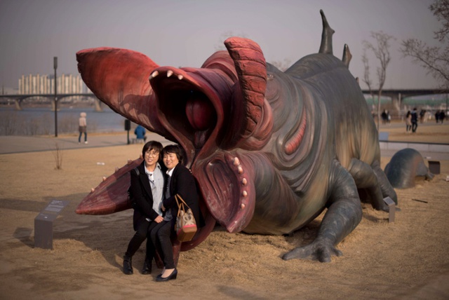 Hai phụ nữ chụp ảnh với mô hình quái vật trong công viên Yeouido ở Seoul, Hàn Quốc.