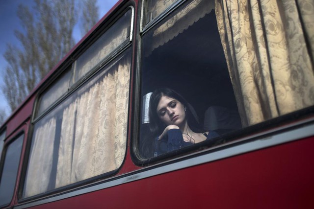 Một phụ nữ ngủ trên xe bus trong khi chờ qua cửa khẩu Uspenka tại biên giới giữa miền đông Ukraine và Nga.