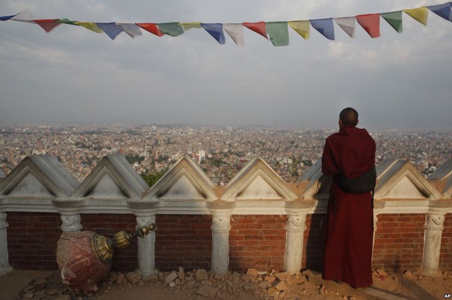 Nhà sư quan sát toàn cảnh thành phố Kathmandu từ tòa tháp Swayambhunath Stupa bị phá hủy trong trận động đất mới đây ở Kathmandu, Nepal.