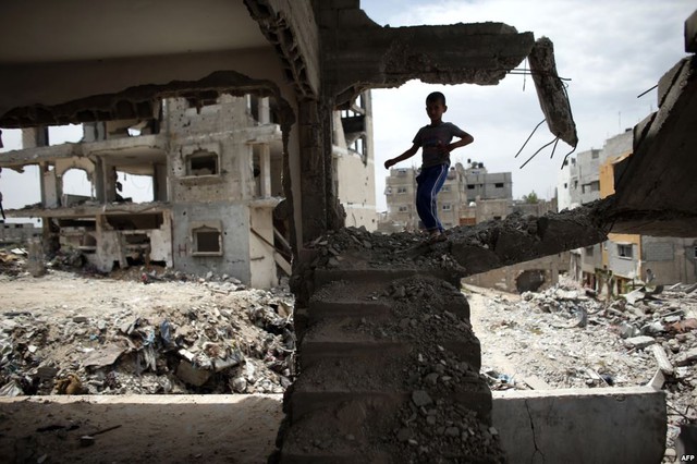 Cậu bé người Palestine chơi giữa đống đổ nát của ngôi nhà bị phá hủy trong cuộc không kích của quân đội Israel vào thành phố Gaza.