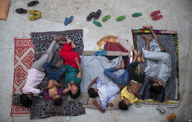 Các thành viên của một gia đình ngủ trên mái nhà để tránh nóng ở New Delhi, Ấn Độ.