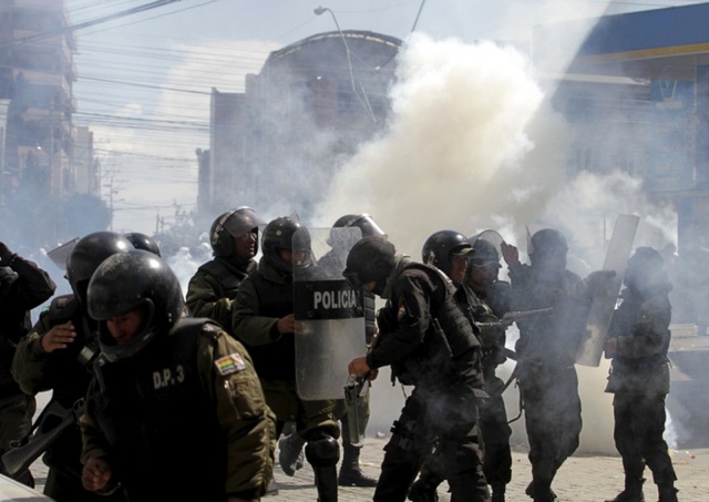 Cảnh sát chống bạo động ném lựu đạn hơi cay để giải tán người biểu tình tại thành phố El Alto, Bolivia.
