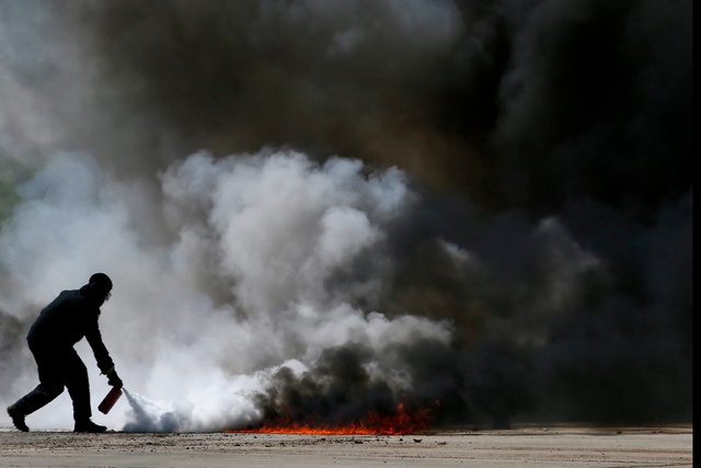 Người đàn ông dập tắt một đám cháy tại triểm lãm quân sự Army-2015 ở Moscow, Nga.