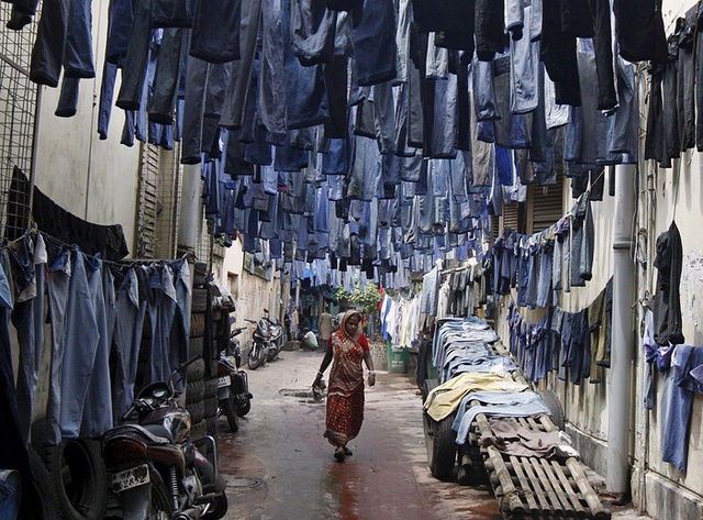 Những chiếc quần jean cũ được phơi khô trước khi được mang đi bán tại chợ quần áo cũ ở Kolkata, Ấn Độ.