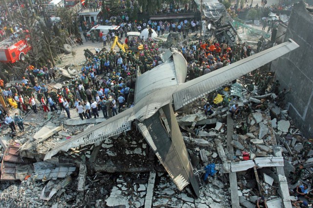 Nhân viên cứu hộ tìm kiếm nạn nhân tại hiện trường máy bay vận tải quân sự rơi xuống khu dân cư ở thành phố Medanin Medan, tỉnh North Sumatra, Indonesia.