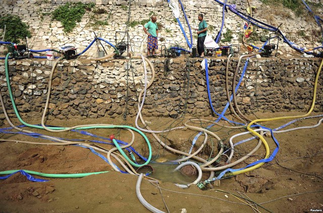 Người dân dùng máy bơm để lấy nước từ hồ gần như cạn khô tại thành phố Bồng Lai, Trung Quốc.