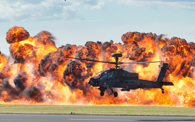 Máy bay trực thăng thăng Apache bay trước bức tưởng lửa trong khi trình diễn tại triển lãm hàng không RIAT ở Gloucestershire, Anh.