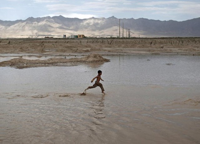 Trẻ em chơi đùa trong vũng nước đục ngầu ở ngoại ô thủ đô Kabul, Afghanistan.