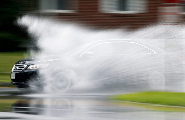 Một chiếc ô tô chạy qua vũng nước trên đường sau mưa lớn tại thành phố Albany, New York, Mỹ.