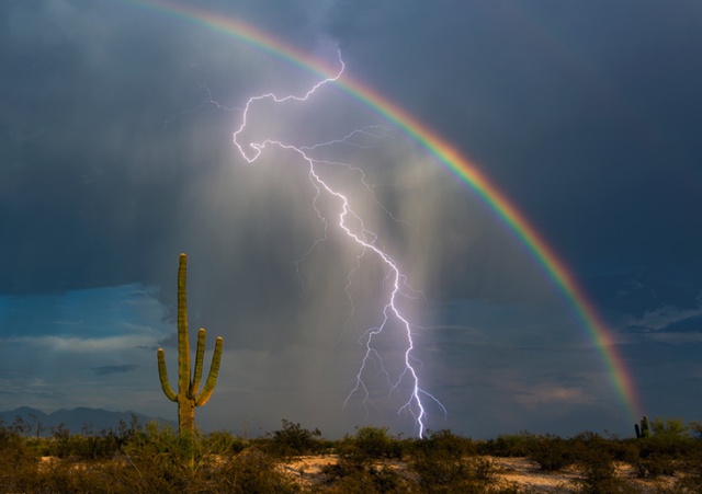 Nhiếp ảnh gia Greg McCown chụp được cảnh tượng sét đánh xuống đất cùng thời điểm cầu vồng xuất hiện ở Marana, bang Arizona, Mỹ.