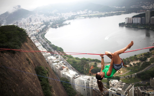 Người phụ nữ đu trên dây được nối giữa hai đỉnh núi gần khu ổ chuột Cantagalo ở Rio de Janeiro, Brazil.