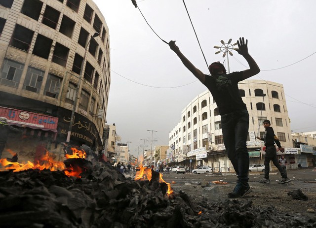 
Người biểu tình Palestine quăng đá vào cảnh sát và binh sĩ Israel trong cuộc đụng độ tại tại thị trấn Hebron, Bờ Tây.
