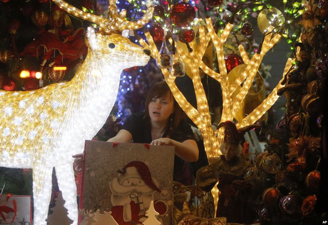 Người phụ nữ trang trí cửa hàng trước dịp lễ Giáng sinh ở thành phố Kiev, Ukraine.
