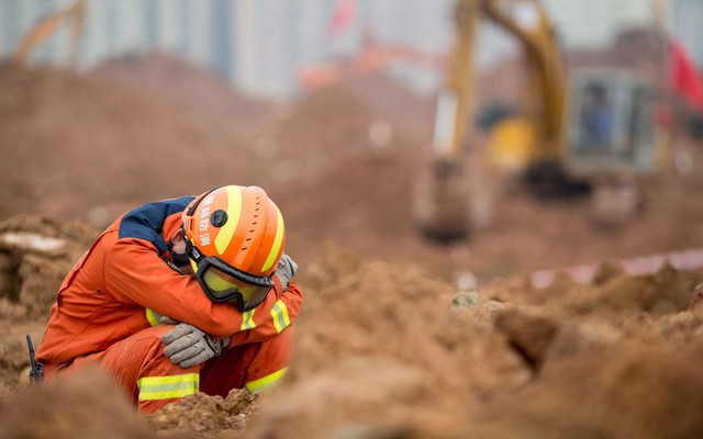 Một nhân viên cứu hộ ngồi nghỉ giữa đống bùn đất tại hiện trường vụ lở đất ở thành phố Thâm Quyến, Trung Quốc.