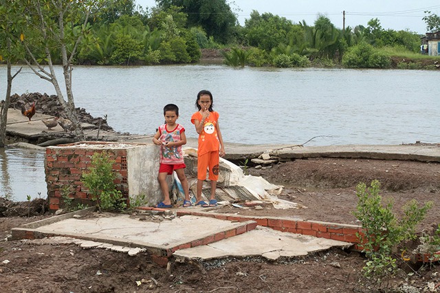 Là một trong những tỉnh có bờ biển dài với ba mặt giáp biển (trên 254km), Cà Mau luôn là điểm nóng xảy ra sạt lở vào mùa mưa bão. Trong ảnh: Hai đứa trẻ đang chơi trên nền một ngôi nhà bị nước dâng lên bất ngờ trong đêm và cuốn trôi vào đầu tháng 9/2015.