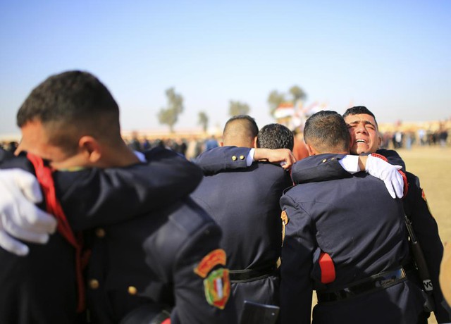 Các học viên ôm nhau trong lễ tốt nghiệp của họ tại một trường quân sự ở Baghdad, Iraq.