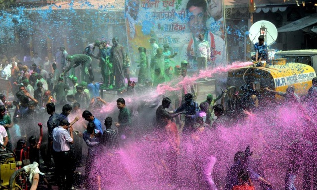Mọi người bị phun nước màu trong khi nhảy múa trên đường phố trong lễ hội Rangapanchami ở Bhopal, Ấn Độ.