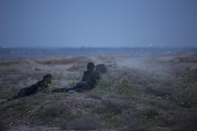 Các chiến binh Hồi giáo dòng xả súng máy nhằm vào phiến quân Nhà nước Hồi giáo (IS) ở ngoại ô thành phố Tikrit, Iraq.