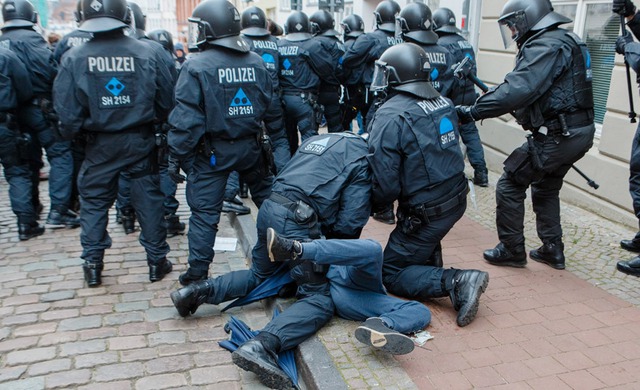 Cảnh sát chống bạo động bắt giữ một người biểu tình phản đối hội nghị Ngoại trưởng G-7 ở Luebeck, Đức.