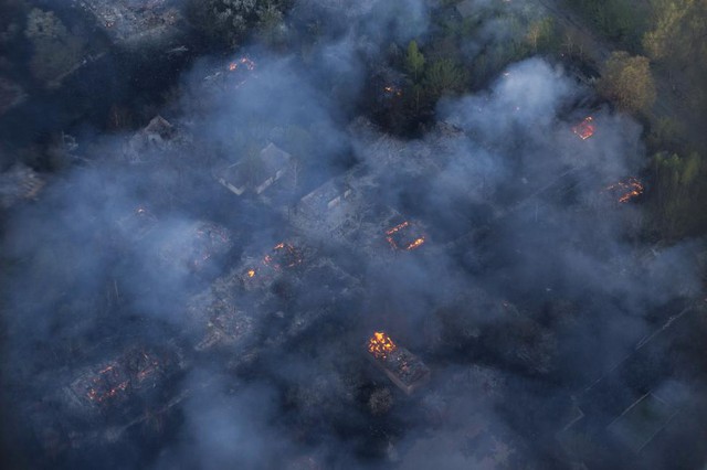 Các ngôi nhà trong một ngôi làng bỏ hoang bị hỏa hoạn thiêu rụi trong một vụ cháy rừng ở miền bắc Ukraine.