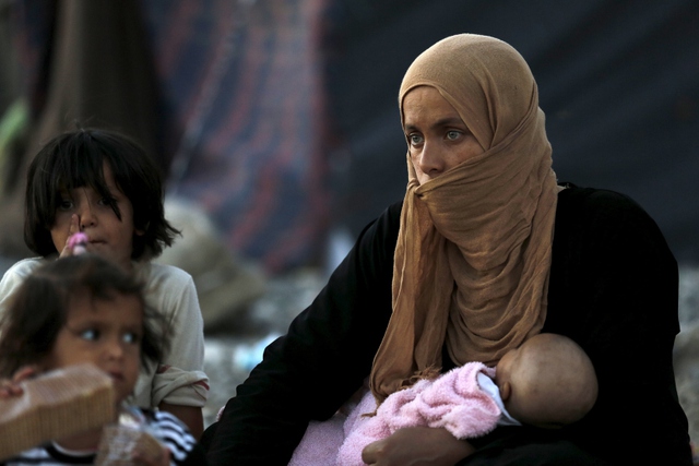 Người phụ nữ Syria cùng con nhỏ ngồi chờ được tị nạn tại tỉnh Sanliurfa, Thổ Nhĩ Kỳ.