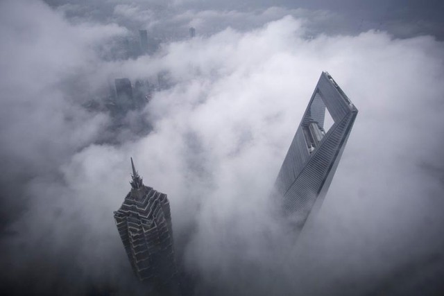 Đỉnh của tòa nhà chọc trời tại thành phố Thượng Hải và tòa nhà Jin Mao Tower được nhìn thấy trong cơn mưa lớn tại khu tài chính của Phố Đông, thành phố Thượng Hải ngày 15/5/2015.