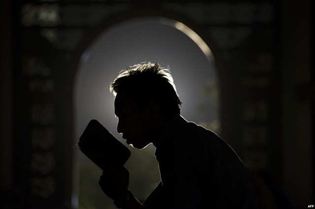 Một người theo đạo Hồi đọc kinh Quran trong tháng lễ Ramadan tại nhà thờ ở Surabaya, Indonesia.