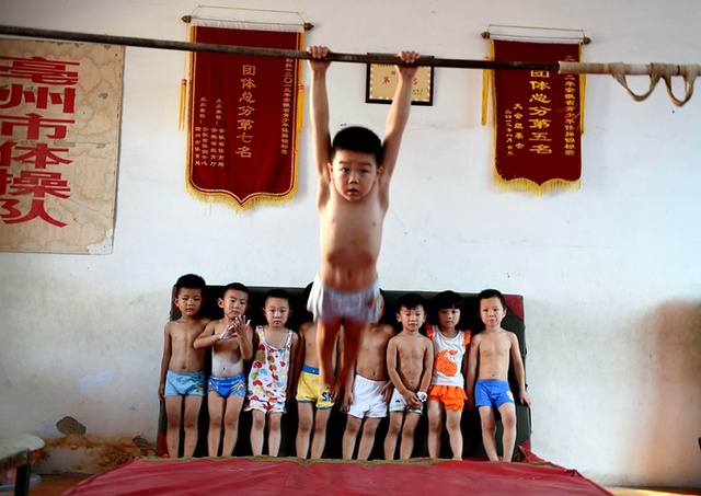Trẻ em luyện tập môn thể dục dụng cụ tại một trại hè ở thành phố Bạc Châu, Trung Quốc.