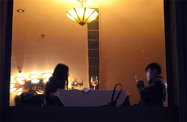 
Chàng thanh niên dán mắt vào màn hình điện thoại trong khi hẹn hò với bạn gái trong khách sạn Solana ở Bắc Kinh.
