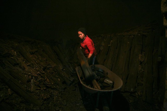 Công nhân thu gom than hoa trong một nhà máy ở Kuala Sepetang, Malaysia.