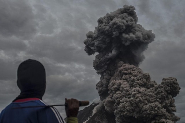 Người dân nhìn tro bụi phun trào lên từ miệng núi lửa Sinabung ở tỉnh North Sumatra, Indonesia.